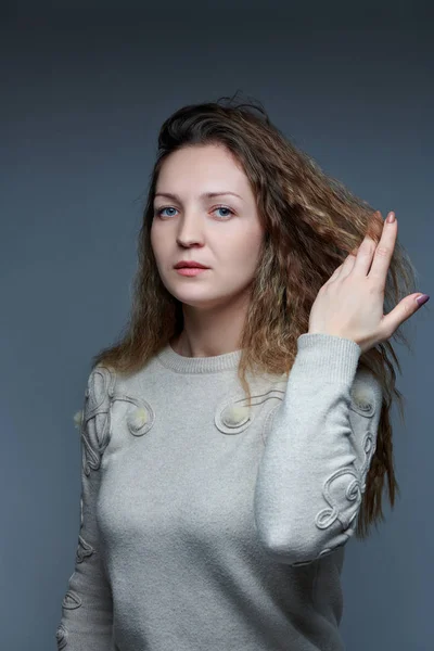 Ung kvinna poserar framför kameran med lockigt hår — Stockfoto