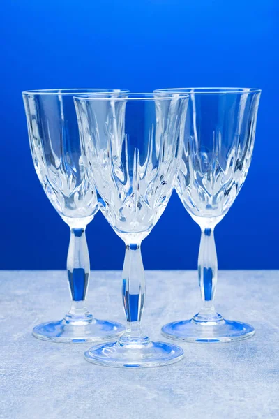 Three crystal glass with close-up on a blue background — Stock Photo, Image