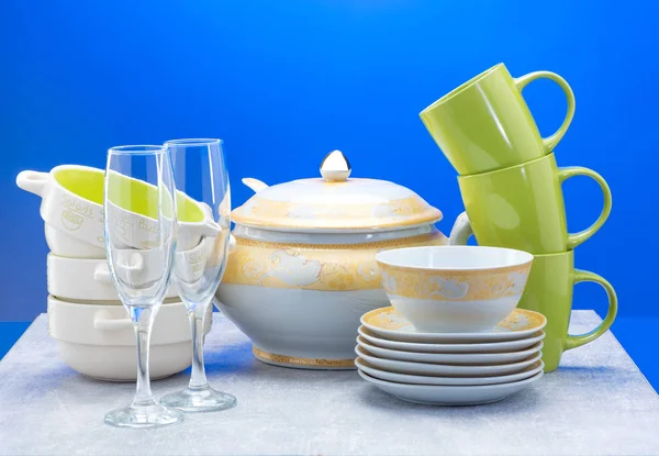 Limpar pratos, copos, copos e talheres em fundo azul — Fotografia de Stock