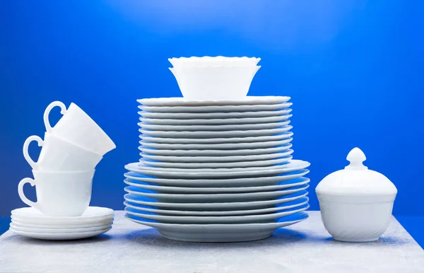 Clean plates, glasses, cups and cutlery on blue background — 图库照片