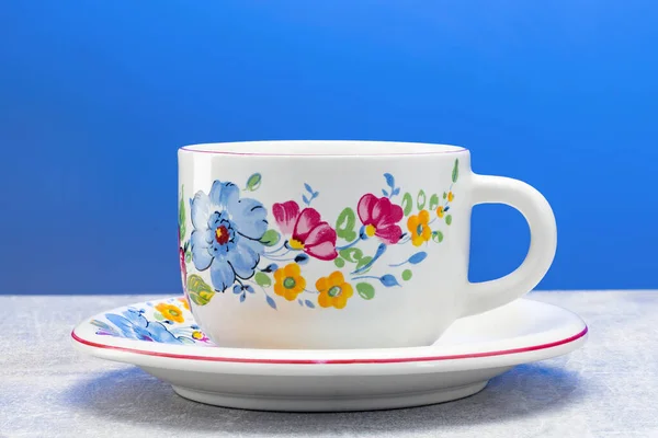 Caneca de cerâmica com ornamento artesanal em um fundo azul — Fotografia de Stock