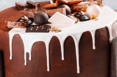 Pasta beyaz çikolata ve kremayla süslenmiş.