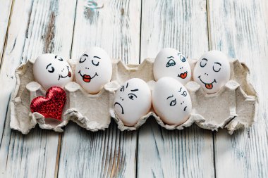 Kırmızı kalpli bir tepsiye boyanmış yumurta.