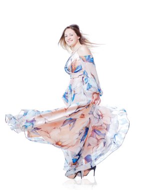 Beyaz arka planda dans eden uzun şık elbiseli bir kız.