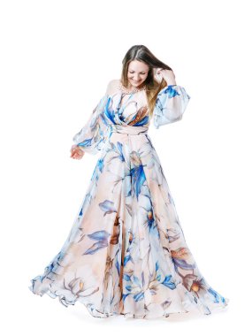 Beyaz arka planda dans eden uzun şık elbiseli bir kız.