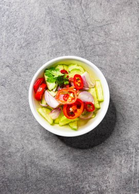 Salatalık, acı biber ve sirkede soğan, moo sat ile servis edilir.