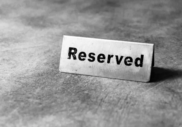 Reserved table sign in restaurant, silver reserved plate, black