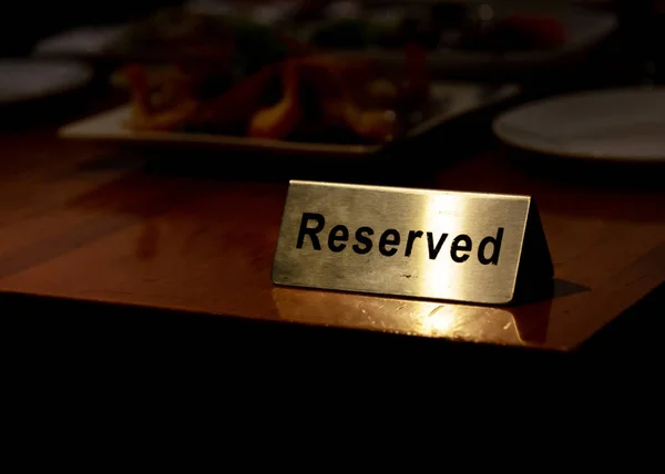 Reserved table sign in restaurant, silver reserved plate