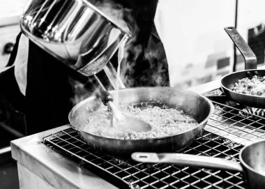 Şef mutfakta yemek hazırlıyor, şef pişiriyor, yakın plan çekiyor.