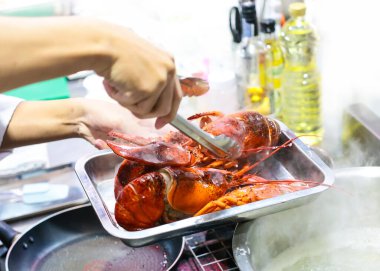 Şef restoran mutfağında ıstakoz hazırlıyor ve pişiriyor. 