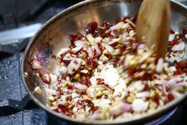 Tavada kavrulmuş sarımsak ve kurutulmuş kırmızı biber baharatı.