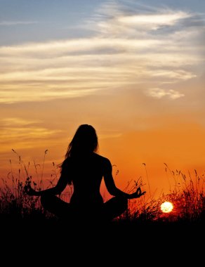 Lotus meditasyon günbatımı arka planda kadın silüeti. Yoga.