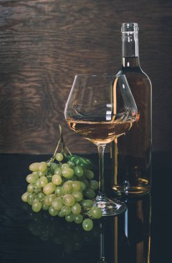 Beyaz şarap şişesi ve şarap kadehi.