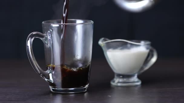 ホットブラックコーヒーとクリームを木の背景にカップに流し込み — ストック動画