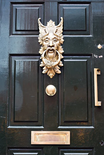 Porta ornamentada batedor em uma porta de madeira — Fotografia de Stock