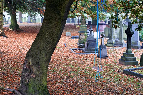 Eine selbst gebastelte Kinderschaukel auf einem Friedhof Stockbild