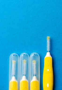 Mavi arka planda interdental alanlar için interdental fırça. T