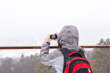 Karlı bir günde kamerayla fotoğraf çeken bir kadın.