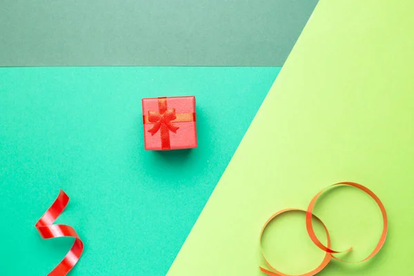 Tarjeta de felicitación minimalista con caja de regalo roja sobre fondo pastel — Foto de Stock