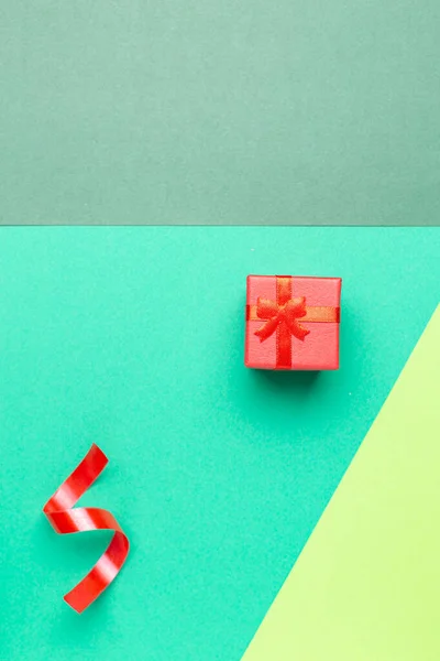 Tarjeta de felicitación minimalista con caja de regalo roja sobre fondo pastel — Foto de Stock