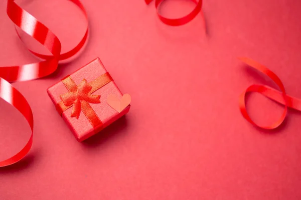 Caja de regalo roja y lazo con lazo sobre fondo rojo — Foto de Stock