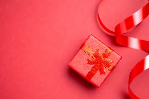 Caja de regalo roja con lazo sobre fondo rojo — Foto de Stock