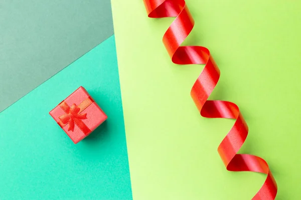 Vista superior de la tarjeta de felicitación minimalista con caja de regalo roja en el pasado — Foto de Stock