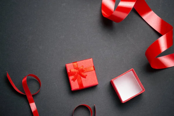 Vista superior de la caja de regalo roja con muchos arco de regalo rojo sobre respaldo negro — Foto de Stock