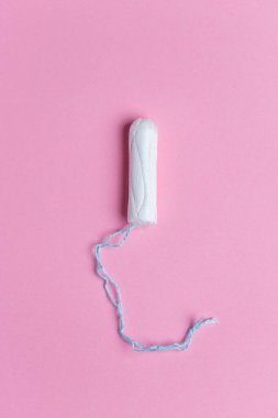 Pembe arka planda tıbbi kadın tamponu. Adet görme, korunma.