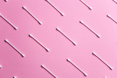 Pembe zemin üzerinde pamuk çubukları ile düz konum kompozisyonu üst görünümü