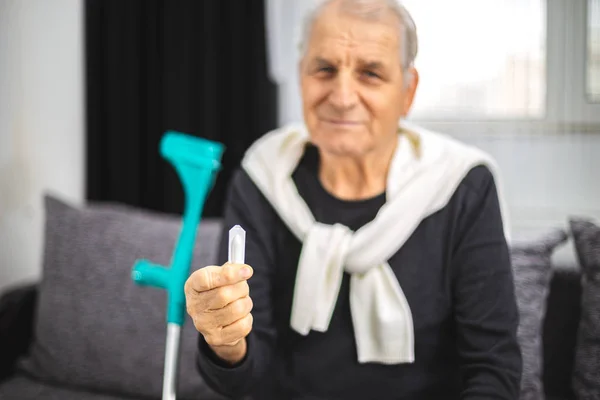 Oudere persoon houdt een helende zetpil van problemen met het rectum, prostaat of aambeien — Stockfoto