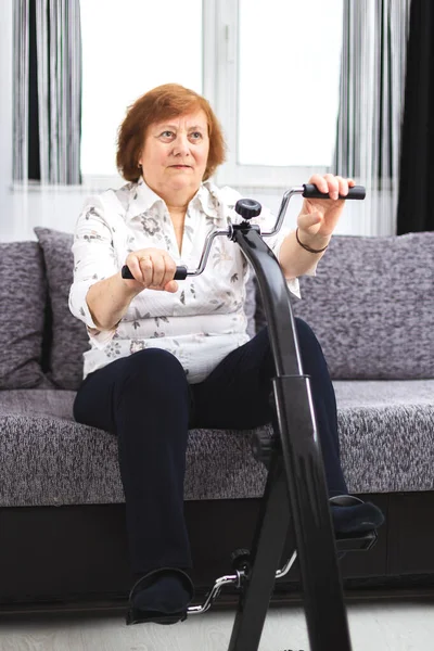 Senior training at home. Senior woman make exercise at home on a — Stock Image Senior training at home. Senior woman make exercise at home on a Stock Image