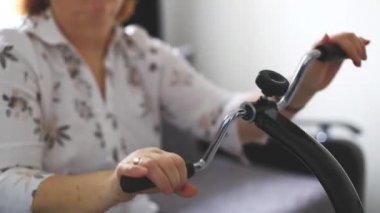 Kıdemli kadın bilek egzersizleri yapıyor. Tıbbi bir cihazda, fizyoterapide.