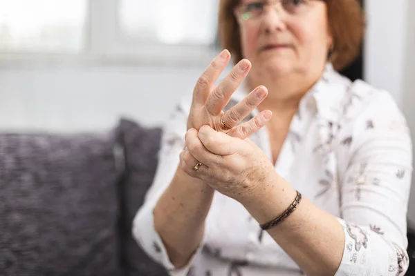 Senior senhora massageando mão sofrendo de artrite reumatoide. Mulher com osteoartrite — Fotografia de Stock
