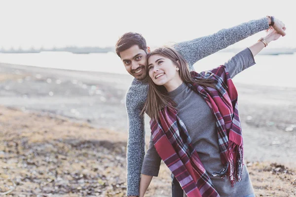 Happy young joyful couple having beach fun moments laughing together in autumn season — Stock Photo, Image