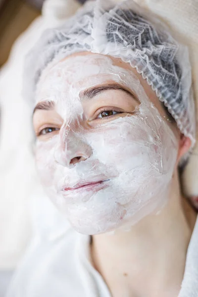 Woman with facial mask. Facial treatment in a spa center.