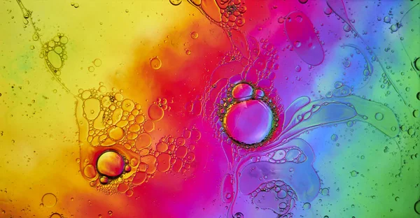 虹色の背景に油と水の泡 — ストック写真