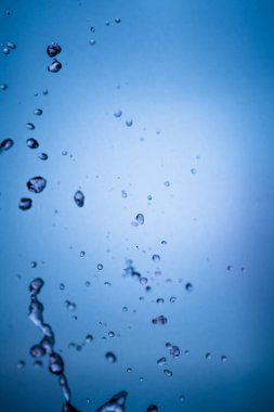 Düşen su damlacıkları ile mavi arkaplan ve doku,