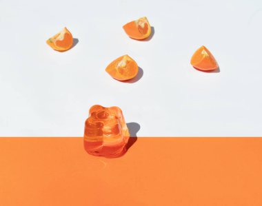 Portakallı, beyaz ve turuncu arka planda turuncu jöle, üst görünüm yatay.