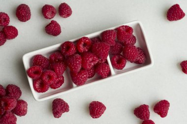 Beyaz arka planda olgun ahududu dolu bir kase. Boşluğu kopyala