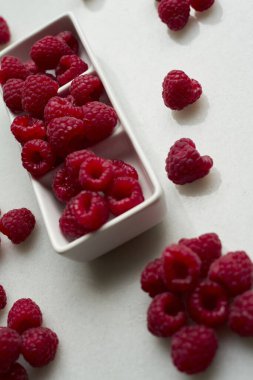 Beyaz arka planda ahududu. Taze ahududulu seramik kutu. Boşluğu kopyala