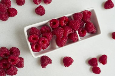 Beyaz arka planda bir kase lezzetli olgun ahududu. Boşluğu kopyala