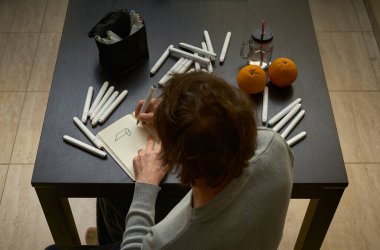 Erkek tasarımcı evde çizimler yapar, evde kalır, evde çalışır.