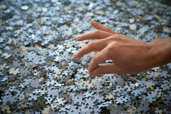 Hand Pakt Een Puzzelstukje Een Stapel Stukjes Thuis Blijven — Stockfoto