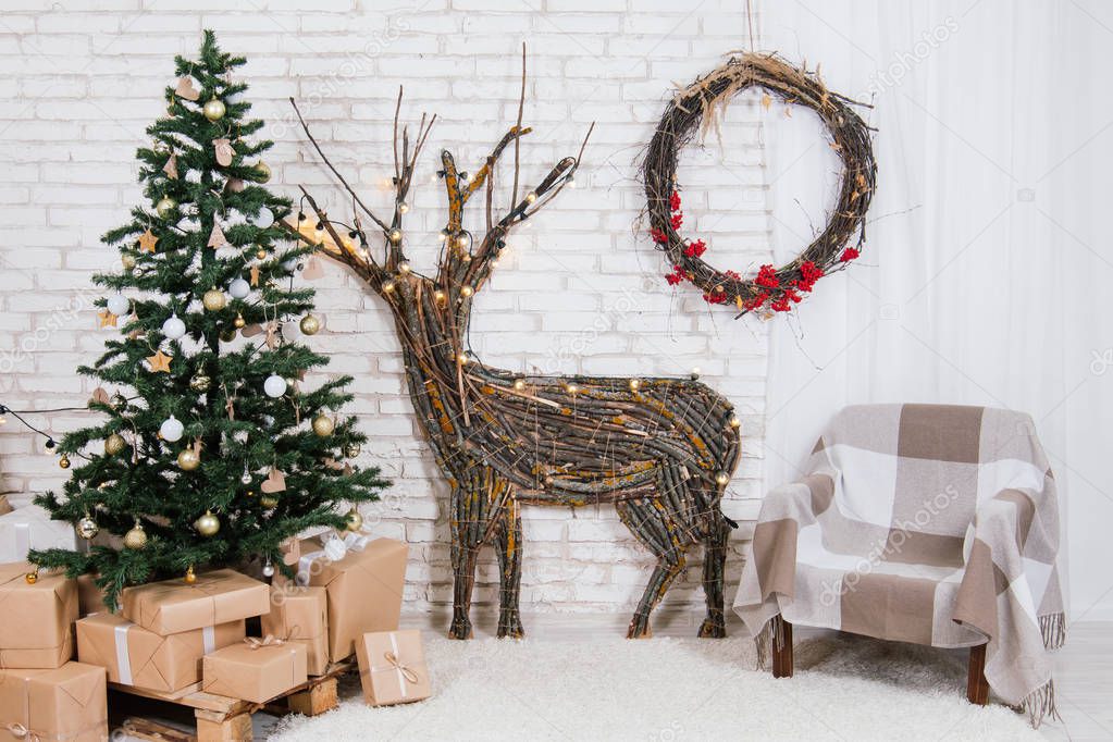 New Year's location in the studio with a deer, decorated with a Christmas tree, gifts, a basket of cones
