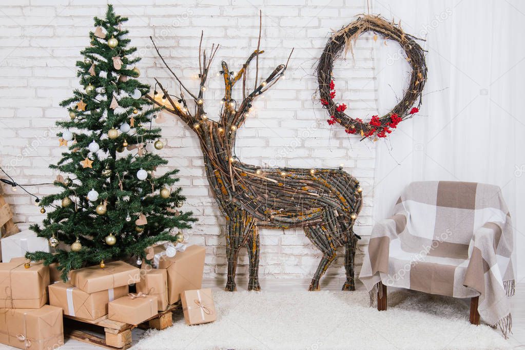 New Year's location in the studio with a deer, decorated with a Christmas tree, gifts, a basket of cones