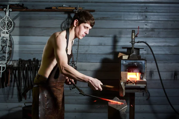 Jeune homme musclé travaillant sur un forgeron avec du métal — Photo