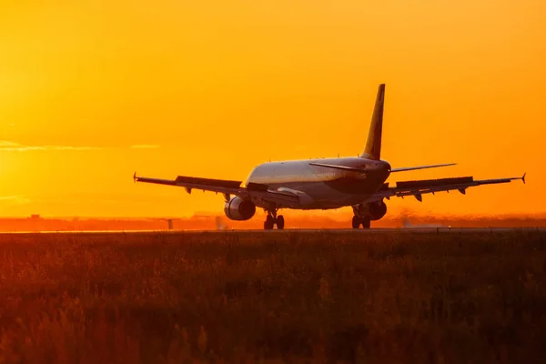 Aterrizar un avión grande durante la puesta del sol — Foto de Stock