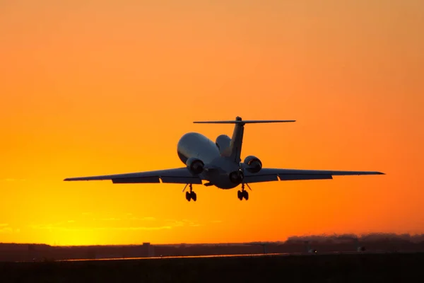 Aterrizar un avión grande durante la puesta del sol — Foto de Stock