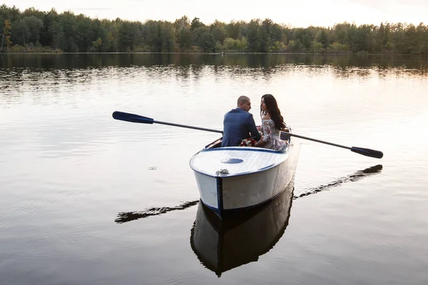 Beautiful young couple boating on the lake at sunset. two people. woman and man — Stock Photo, Image